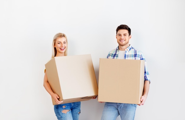 ein glückliches Paar mit Kisten, das in ein neues Zuhause umzieht