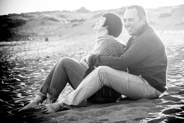 Ein glückliches Paar sitzt am Ufer am Strand