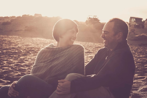 Foto ein glückliches paar sitzt bei sonnenuntergang am strand