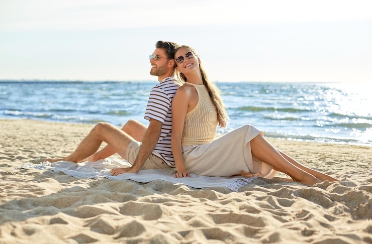 Foto ein glückliches paar sitzt rücken an rücken am sommerstrand