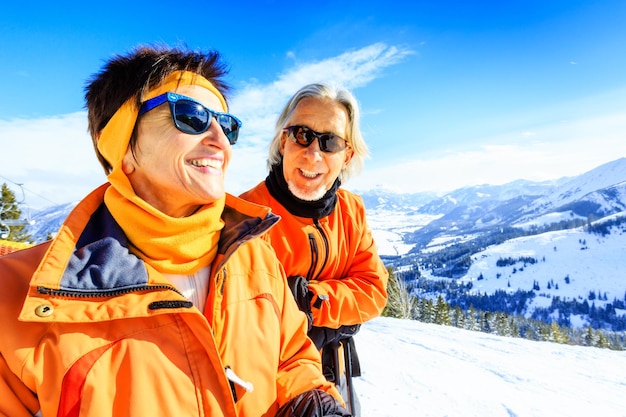 Foto ein glückliches seniorenpaar steht auf einem schneebedeckten berg