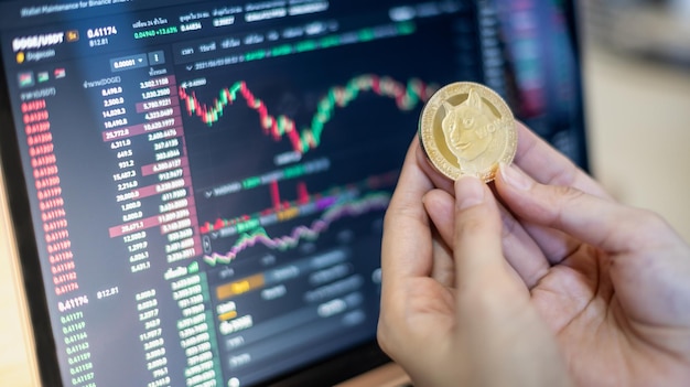 Ein goldener Dogecoin Doge mit Kryptowährung in der Hand Geschäftsfrau mit der Grafik für den Handel