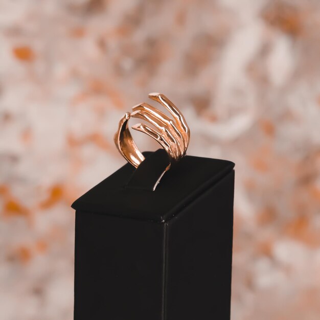 Ein goldener Ring auf einer schwarzen Schachtel mit rosa Hintergrund