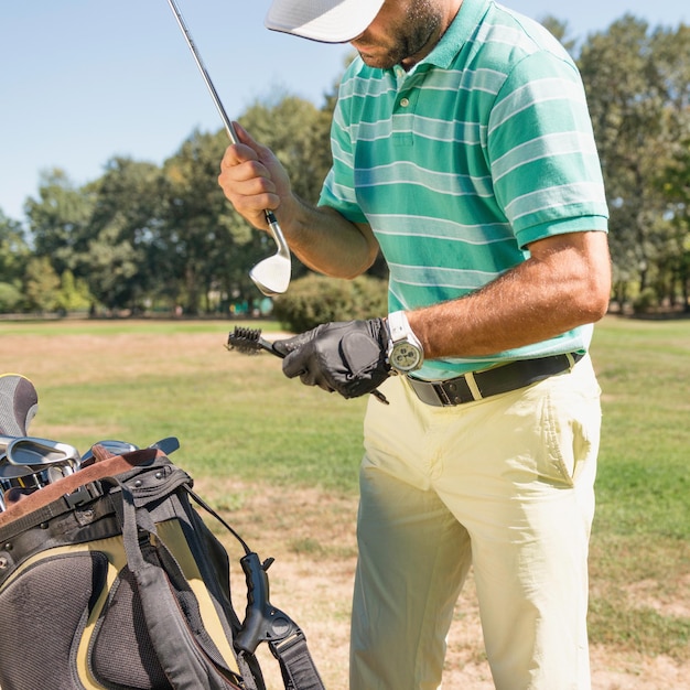 Ein Golfer reinigt einen Club