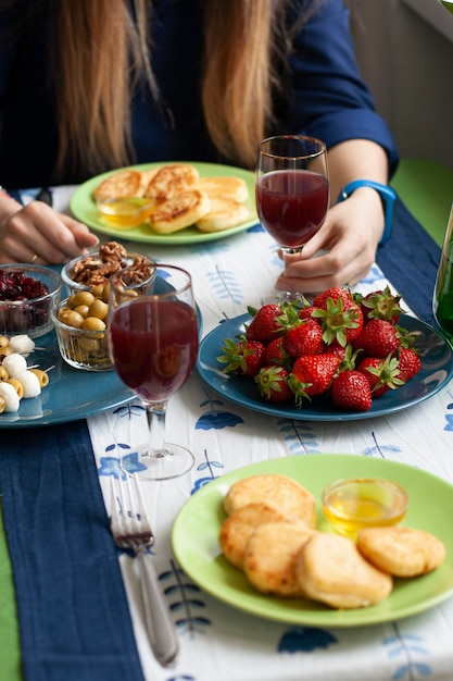 Ein Gourmet-Frühstück für zwei: Syrnyky, Erdbeeren, Traubensaft und verschiedene Vorspeisen.