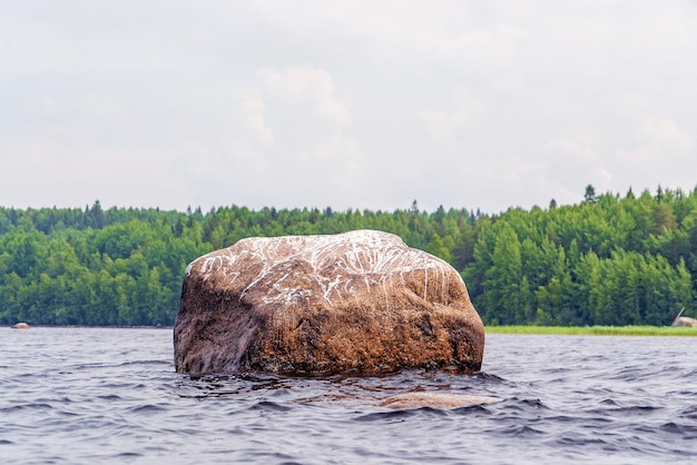 Ein Granitstein ragt aus dem Wasser des Ladogasees