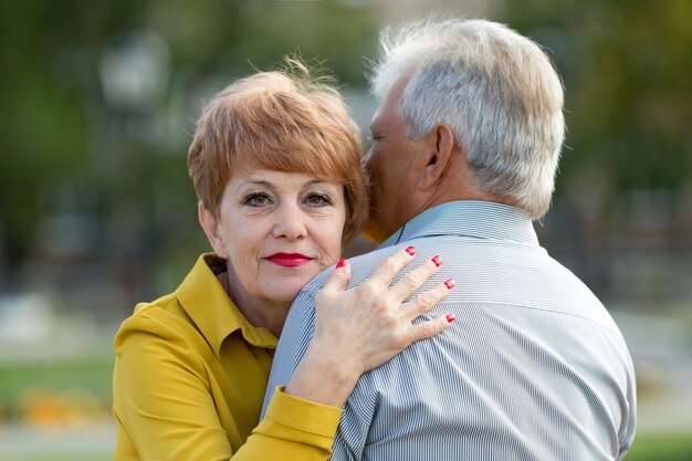 Ein grauhaariger Mann mit seiner Frau im Park