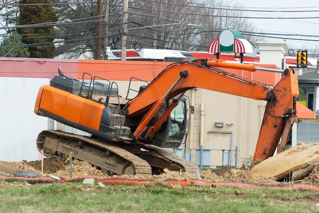 Ein großer Baubagger in gelber Farbe auf der Baustelle