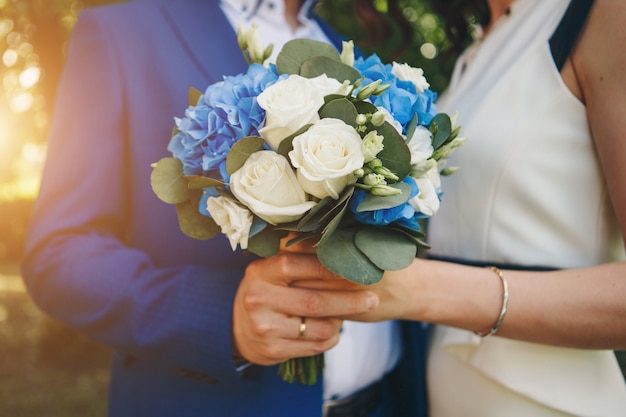 Ein großer Blumenstrauß Rosen in den Armen der Braut