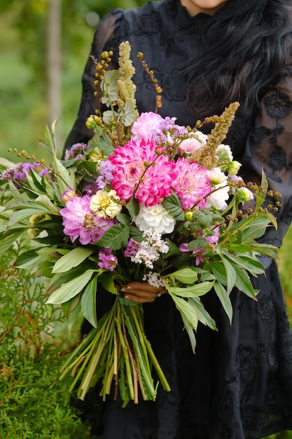 Foto ein großer bouquet gemischter blumen in den händen einer frau die arbeit eines blumenhändlers in einem blumenladen