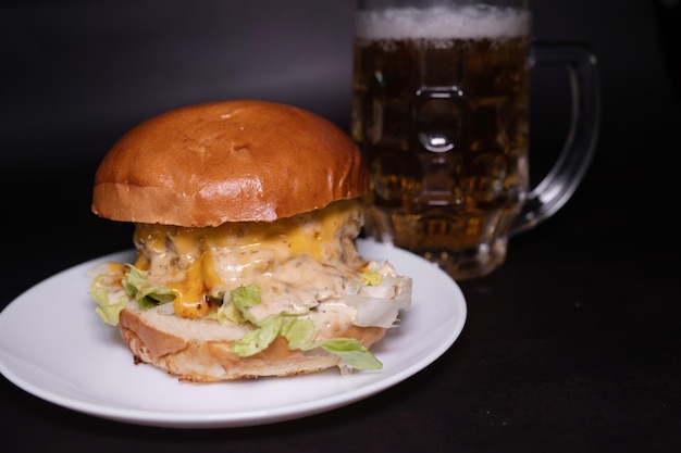 Ein großer Burger mit einem Bier daneben