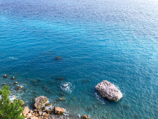 Foto ein großer felsen im wasser mit dem meer im hintergrund