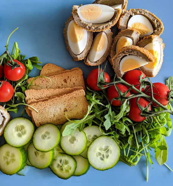 Ein großer frischer Salat mit Tomaten, Eiern, Gurkenkresse saß auf einem hellblauen Brett