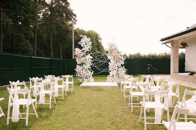 Foto ein großer goldener bogen mit einem weißen podium, das mit blumen in der natur geschmückt ist