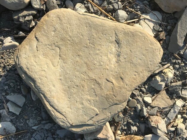 Ein großer Stein liegt auf einem Meerkiesel am Strand. Stück Fels. Foto in hoher Qualität