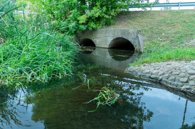 Ein großes Betonrohr zur Umleitung des Flusses unter der Autobahn Auslaufendes schmutziges Wasser aus großen Betonrohren Schmutziges Abwasser aus dem Rohr Umweltverschmutzung Umweltproblem