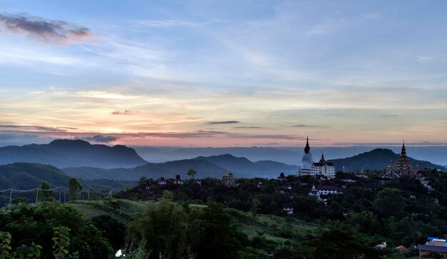 Ein großes Buddha-Bild und ein Tempel auf einem Hügel mit farbenfrohem Dämmerungshimmel in einer Sonnenuntergangszeit