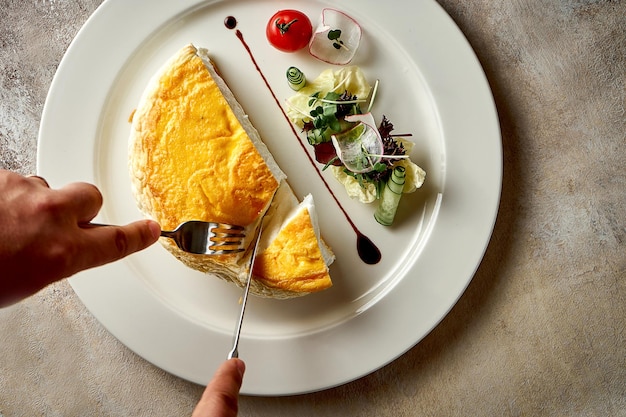 Ein großes Eieromelett mit Salat auf einem weißen Teller Selektiver Fokus Rauschen in der Postproduktion