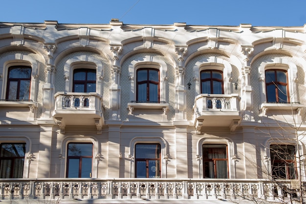 Ein großes Steingebäude mit vielen Fenstern. Altes klassisches Architekturhaus mit vielen Bogenfenstern und Balkonen. Schöne Palastfassade