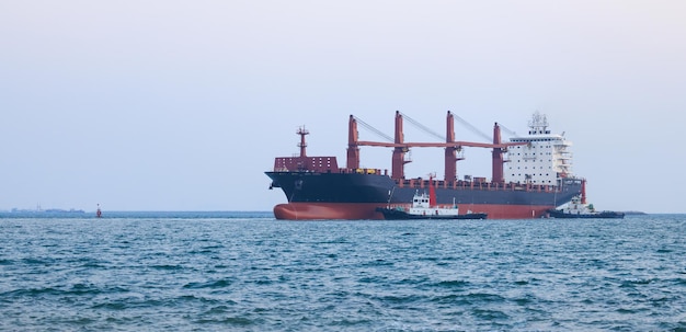 Ein großes Tragerschiff schwimmt am Nachmittag in einem Schleppboot