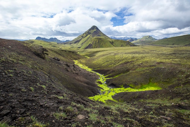 Ein grüner Berg und ein moosiger Fluss auf der 54 km langen Wanderung von Landmannalaugar Island