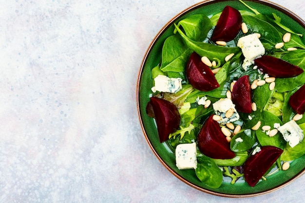 Ein grüner Teller Rübensalat mit Blauschimmelkäse an der Spitze