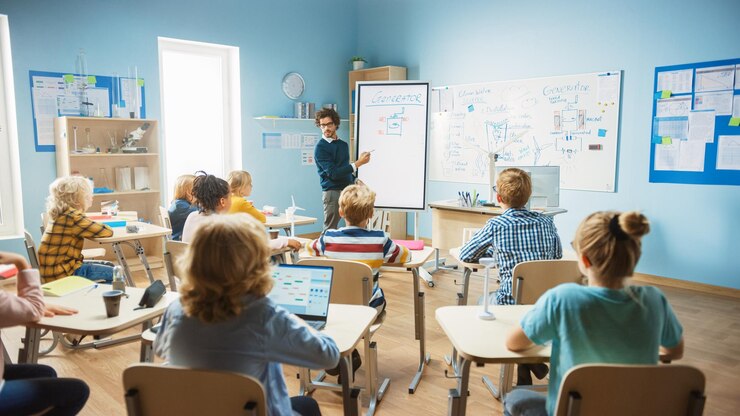Foto ein grundschullehrer in physik benutzt ein interaktives digitales whiteboard, um einem klassenzimmer voller intelligenter, vielfältiger kinder zu zeigen, wie ein generator funktioniert.