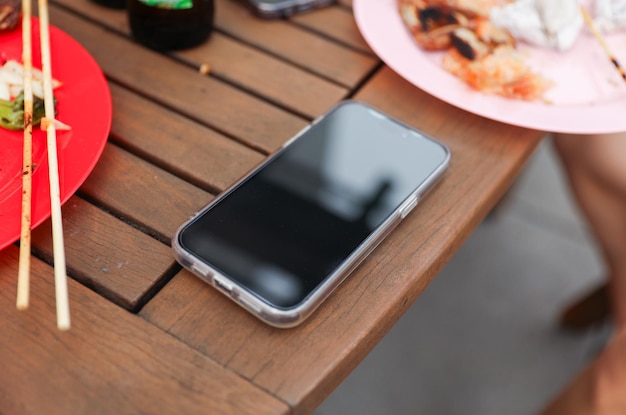 Ein Handy liegt auf einem Tisch mit einem Teller voller Essen und einem Teller mit Essen.