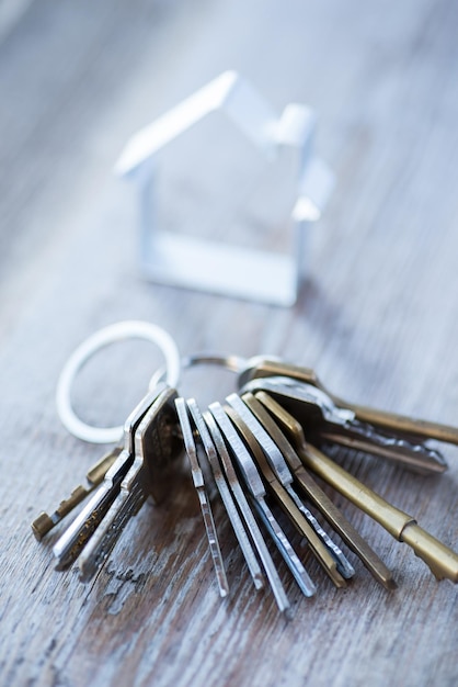 Ein Haufen alter, abgenutzter Schlüssel mit Metallhaus auf der Holzoberfläche