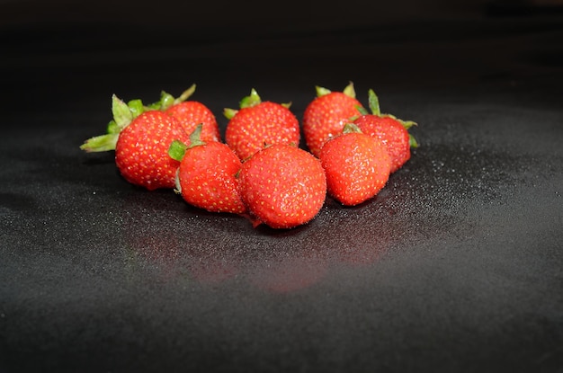 Foto ein haufen erdbeeren auf einem schwarzen tisch