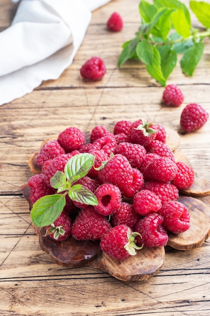 Ein Haufen frischer saftiger Himbeeren auf einem Holzbrett