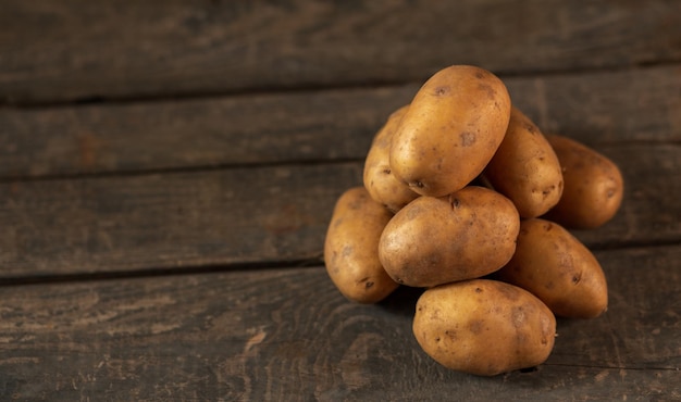 Ein Haufen Kartoffeln auf dem Hintergrund einer Holzkiste Konzept ein Haufen Kartoffeln Gemüsegarten Landwirtschaft Landwirtschaft