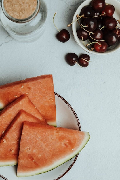 Ein Haufen Sommer und frisches Obst über einem minimalistischen weißen Tisch, Wassermelone und Kirsche, Wellness- und gesunde Lebensmittelkonzepte, leckerer, strukturierter, Kopienraum