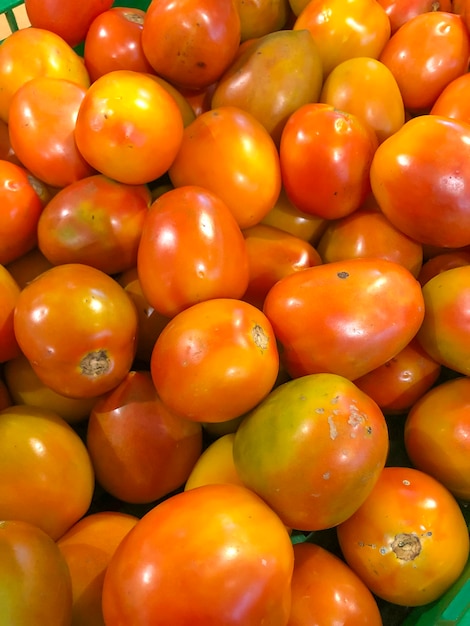 Ein Haufen Tomaten oder Tomaten, bei einer davon fehlt der Stiel