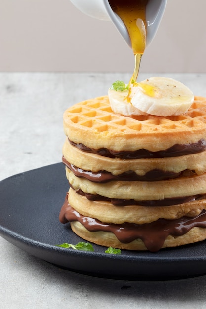 Ein Haufen Waffeln gefüllt mit Haselnussbanane und Honig