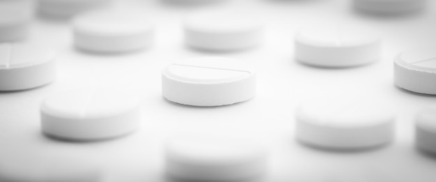 Ein Haufen weißer Pillen, die auf einem hellweißen Hintergrund verstreut sind Selektiver Fokus Mockup-Layout-Vorlage