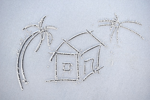 Ein Haus auf Sand gemalt. Mietwohnungen in den Tropen. Haus am Strand. Unterkunft zum Meer. Immobiliendienstleistungen an der Küste. Ein Haus am Meer kaufen.