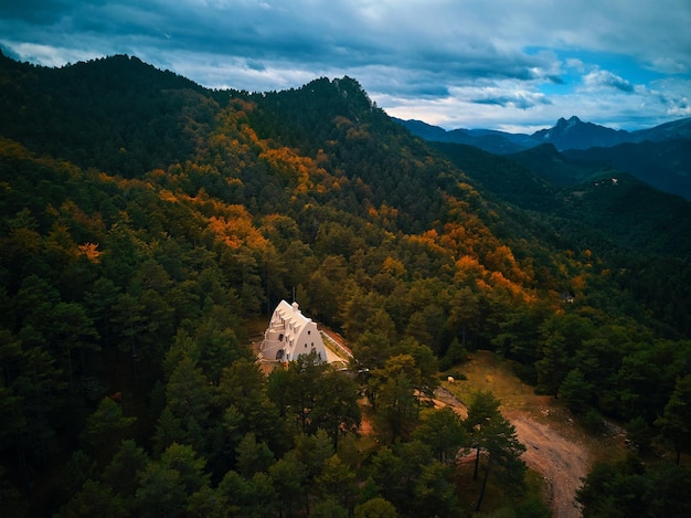 Ein Haus in den Bergen mit einem bewölkten Himmel im Hintergrund