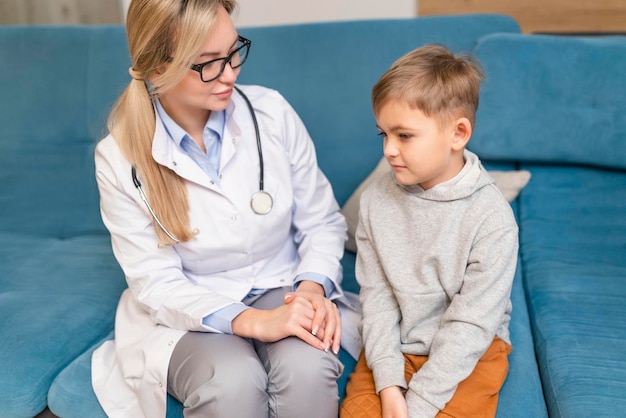 Ein Hausarzt untersucht einen kleinen Jungen zu Hause Kinderarztmädchen behandelt ein Kind