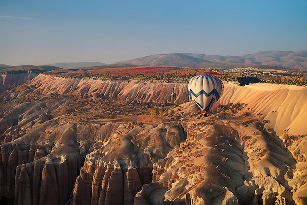 Ein Heißluftballon schwebt über einem Tal in Kappadokien.