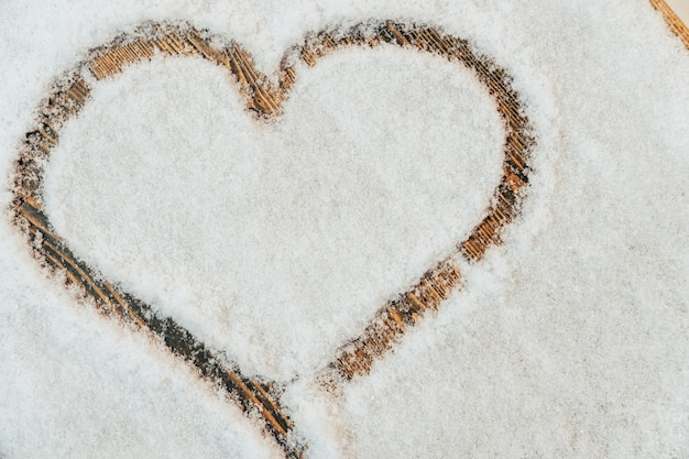 Ein Herz mit dem Finger auf den Schnee gezeichnet