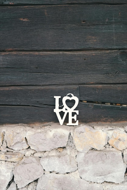 ein herzförmiger Metallbuchstabe i und das Wort Love an einer Steinmauer