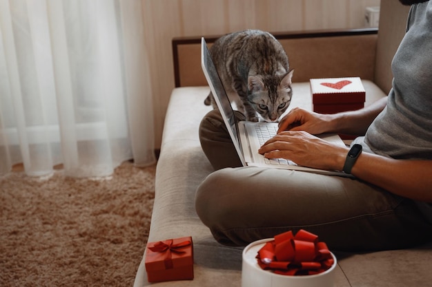 Ein Hipster-Mann mit einer roten Tasse, der zur Weihnachtszeit zu Hause sitzt