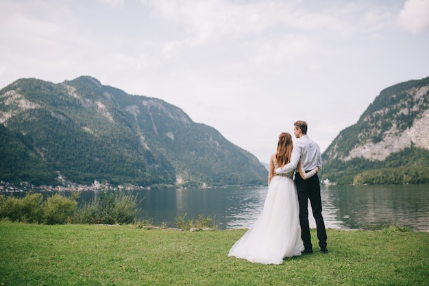 Foto ein hochzeitspaar auf dem hintergrundsee und den bergen in der märchenstadt von österreich