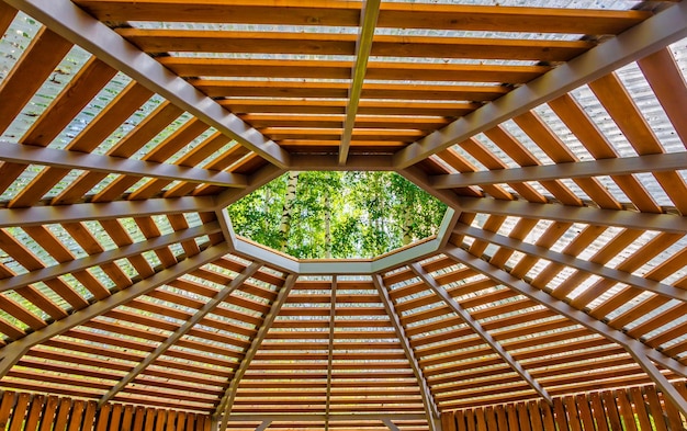 Ein hölzerner Pavillon mit Oberlicht und die Sonne scheint durch das Dach.