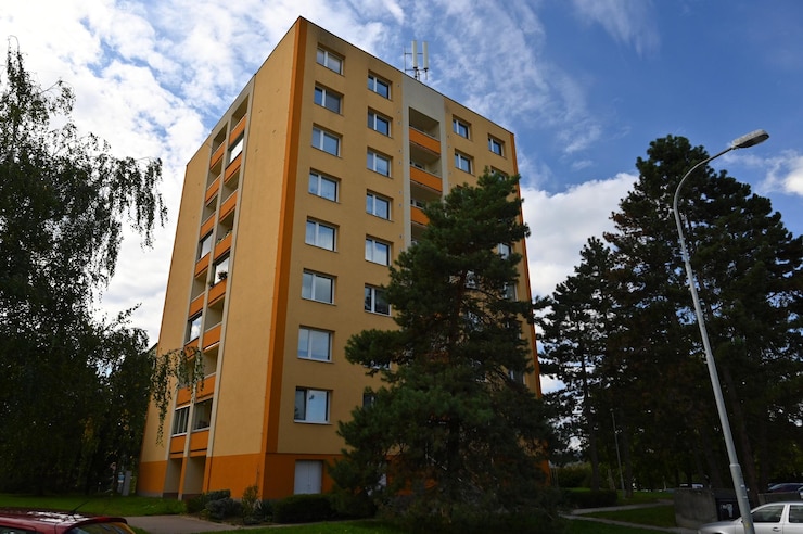 Foto ein hohes orangefarbenes gebäude mit vielen fenstern und einem baum davor