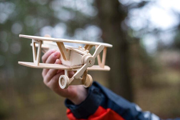 Foto ein holzflugzeug in den händen eines kindes