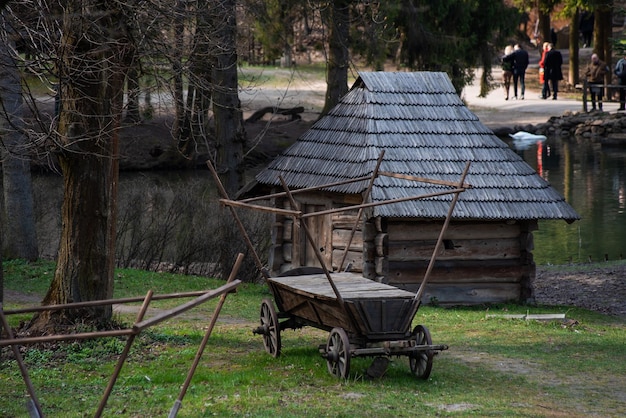 Ein Holzhaus mit Holzdach und ein Holzwagen mit Holzdach.