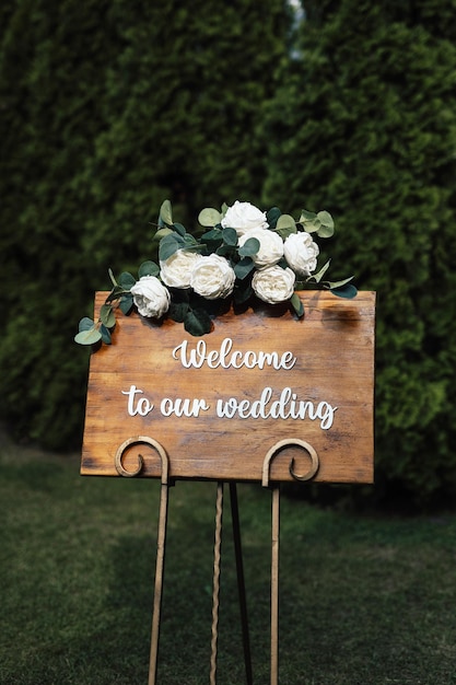 Ein Holzschild mit der Aufschrift „Willkommen zu unserer Hochzeit“.