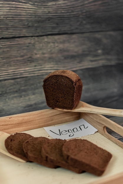 Ein Holztablett mit einem Stück veganem Brot darauf